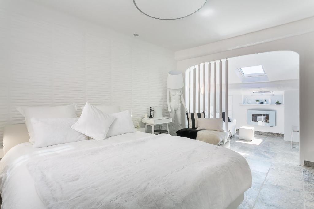 a white bedroom with a white bed and a desk at My Pad Provence 5 in Avignon