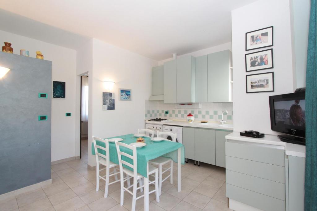 a kitchen with a table and chairs and a tv at Residence Vives in Comacchio