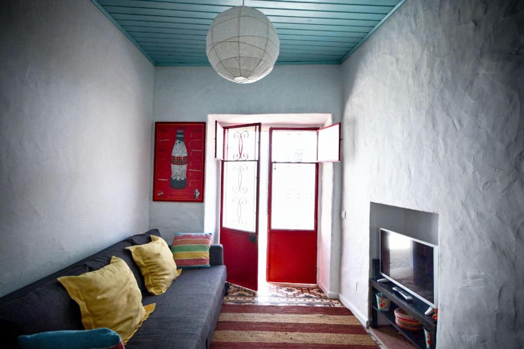 a living room with a couch and a red door at Traditional House in Historical Center of Faro in Faro