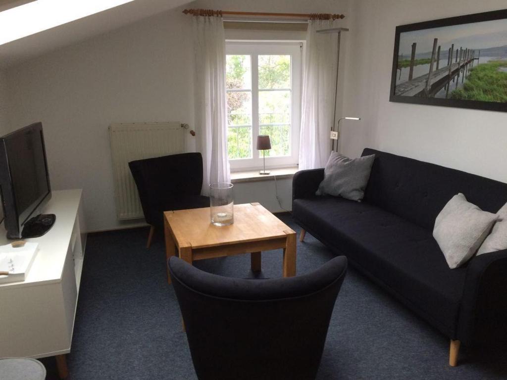 a living room with a couch and a table at Ferienwohnung-Himmelblau-auf-dem-Ferien-Bauernhof-Nielson-in-Bisdorf-in-Inselmitte in Bisdorf