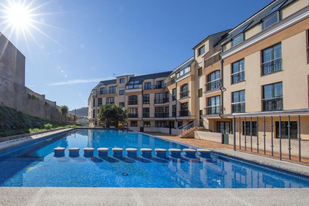 una piscina frente a algunos edificios en Apartagal-Apartamentos Espasante, en Porto de Espasante