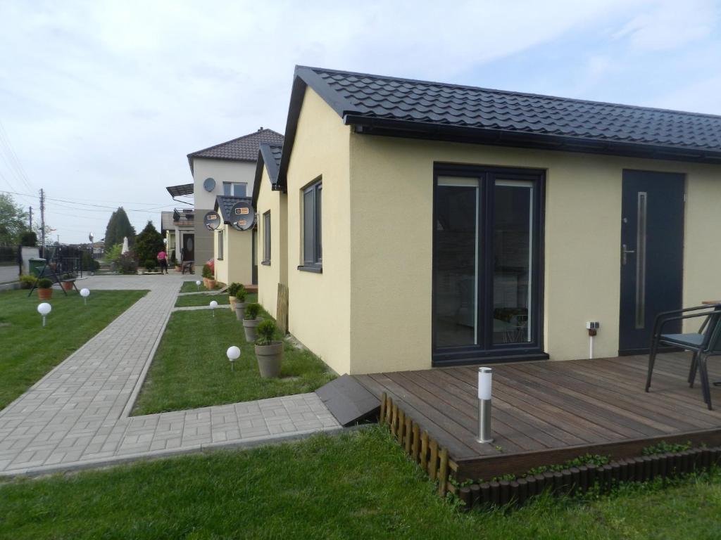 a house with a wooden deck in the yard at Dobranocka - pokoje i całoroczne domki blisko Energylandii in Zator