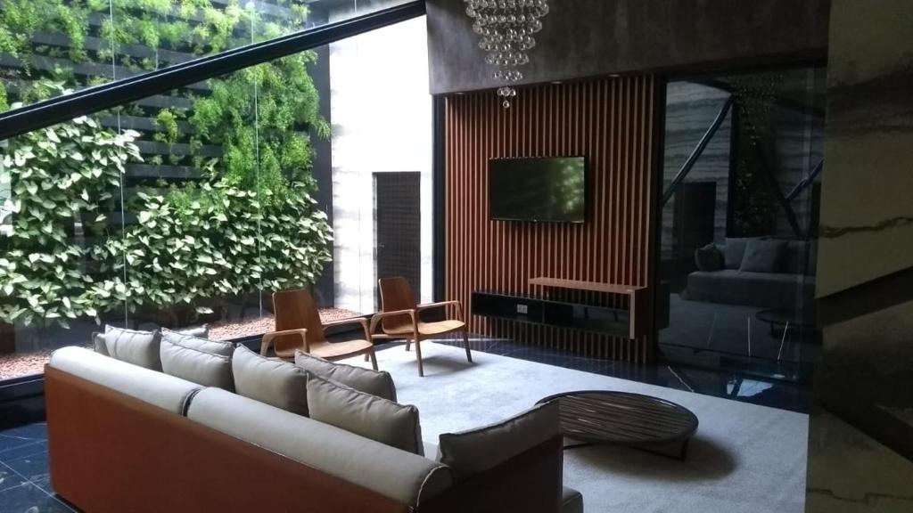 a living room with a couch and a tv at Apartamento de luxo no coração da ponta verde in Maceió