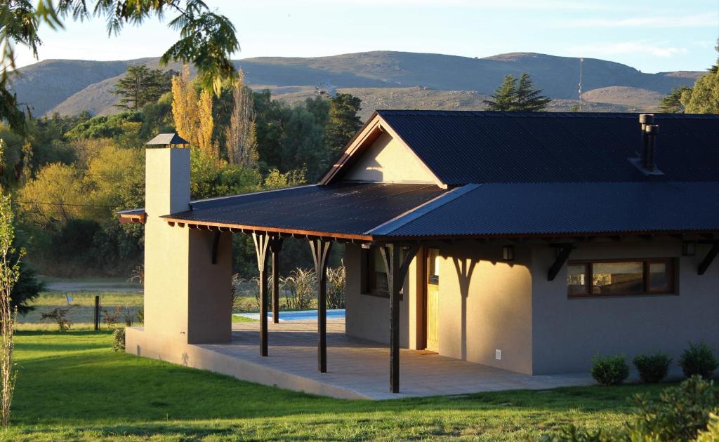 een huis met een zwart dak en een tuin bij Casa Retama Boutique in Sierra de la Ventana