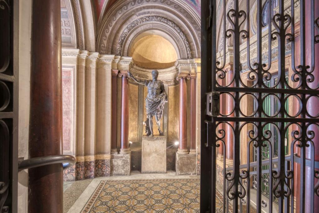 a gate in a building with a statue behind it at Florea Palace in Rome