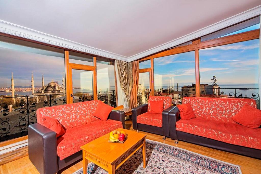 a living room with red couches and a large window at Lausos Hotel Sultanahmet in Istanbul