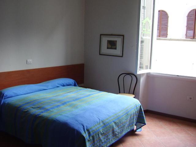a bedroom with a blue bed and a window at 27 Aprile in Florence
