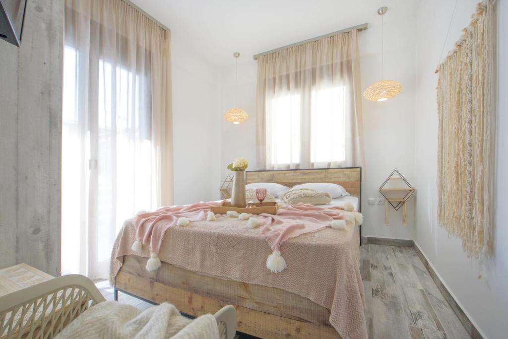 a bedroom with a wooden bed with a pink blanket at Meltemi luxury apartments in Nea Roda