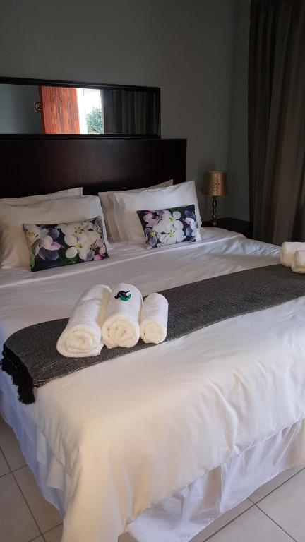 two beds in a hotel room with towels on them at Silver Rest Guesthouse in Mahikeng