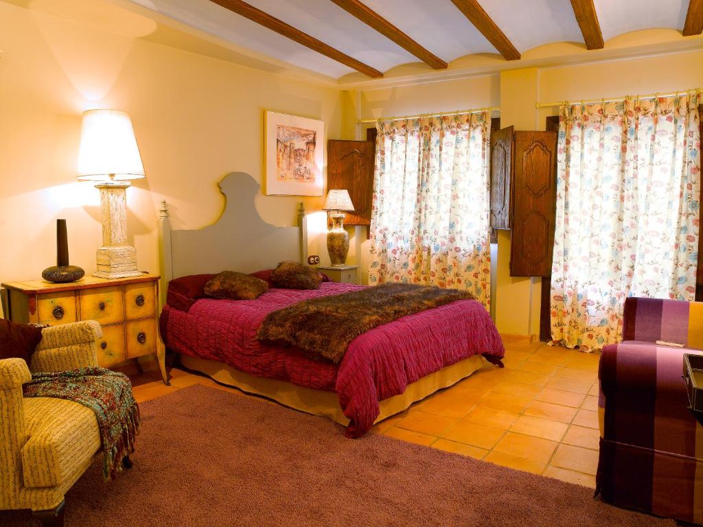 a bedroom with a bed and a couch and a chair at Casa Miñón in Buera