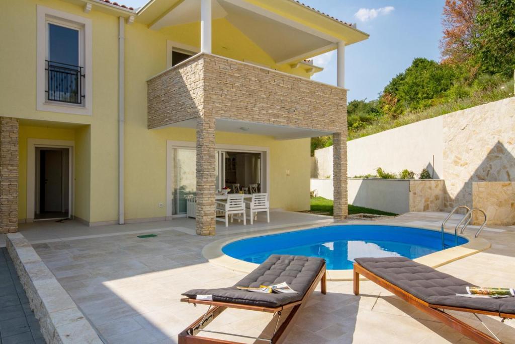 a backyard with a swimming pool and a house at House Sunny Rock Baška in Jurandvor