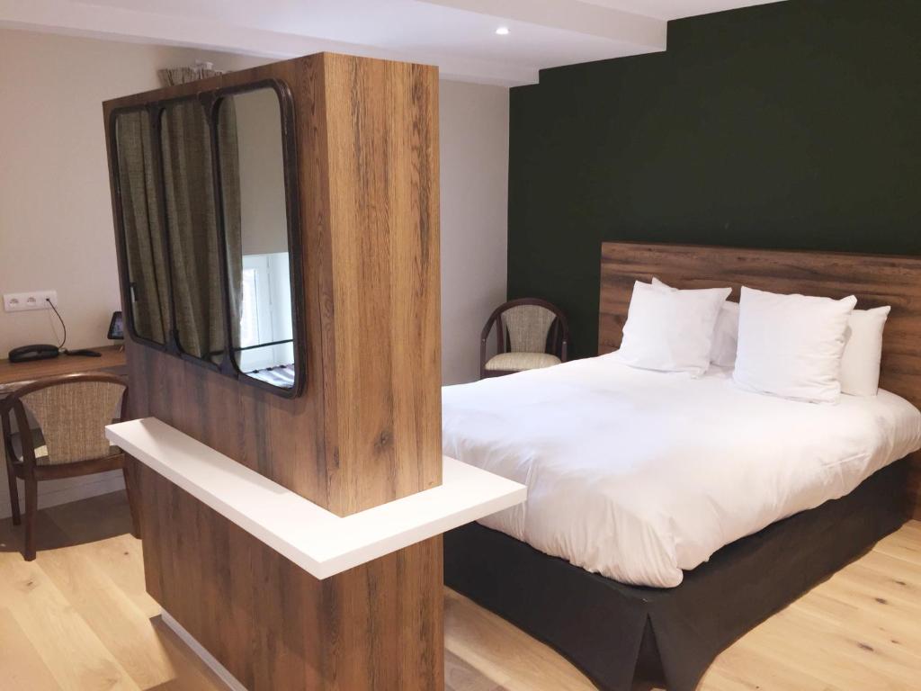 ein Schlafzimmer mit einem Bett und einem Spiegel darauf in der Unterkunft Aux Terrasses in Tournus
