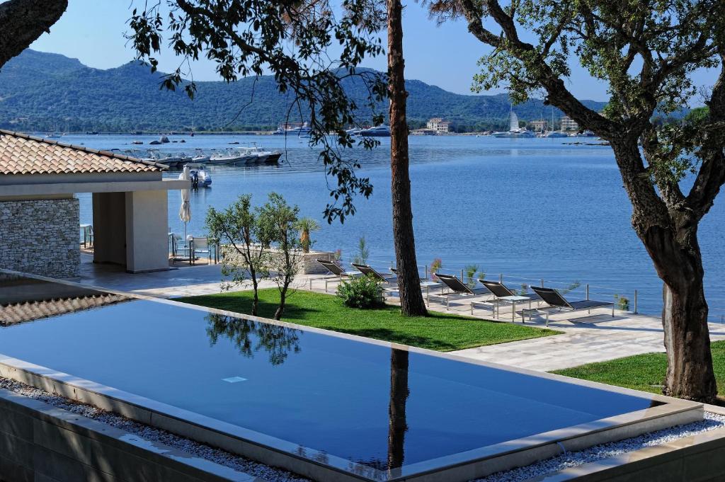 una piscina con vista sull'acqua di Hotel Don Cesar a Porto Vecchio