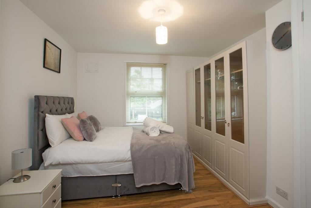 チェルムスフォードにあるVictoria’s Placeのベッドルーム1室(白いシーツとピンクの枕が備わるベッド1台付)