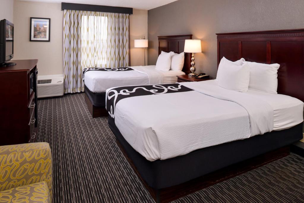 a hotel room with two beds and a television at La Quinta by Wyndham Indianapolis South in Indianapolis