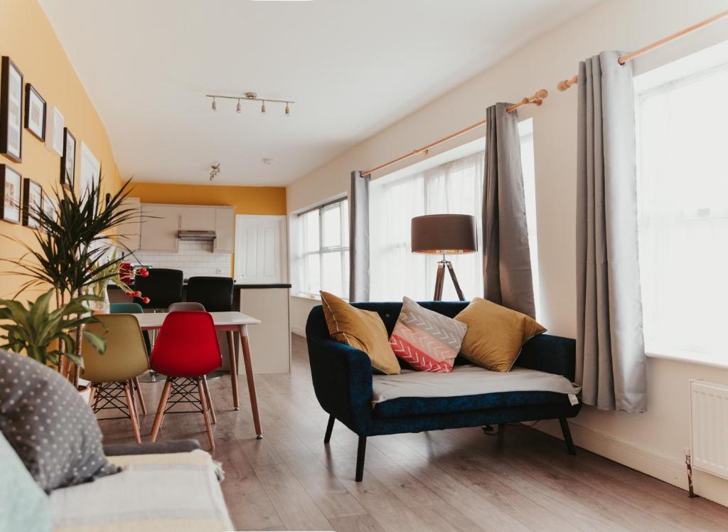 un soggiorno con divano e tavolo di The Margate Sands Apartment - Margate Old Town - By Goldex Coastal Breaks a Margate
