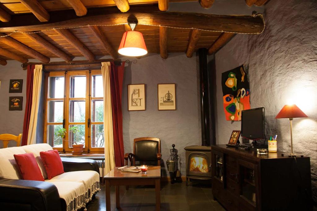 ein Wohnzimmer mit einem Sofa und einem TV in der Unterkunft La Herrera ll in San Esteban de la Sierra