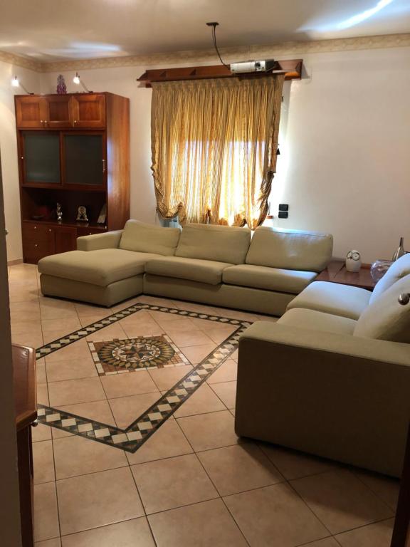 ein Wohnzimmer mit 2 Sofas und einem Fenster in der Unterkunft Casa di Antonello in Cosenza