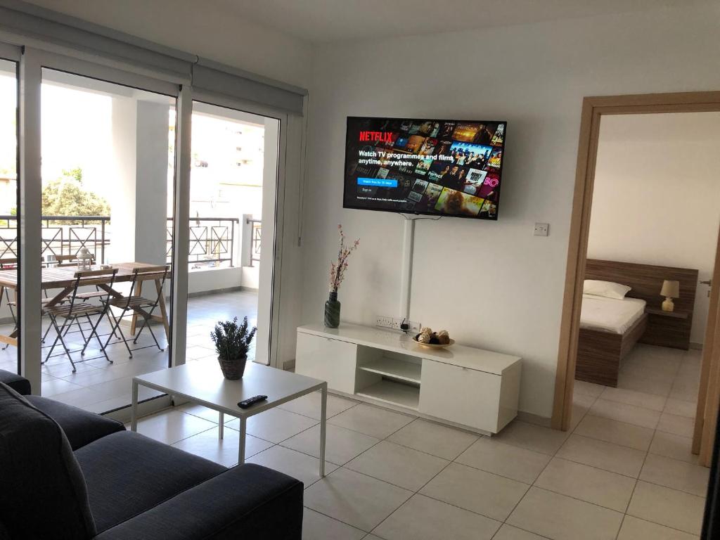 a living room with a couch and a tv on the wall at Must Stay - City Center in Larnaca