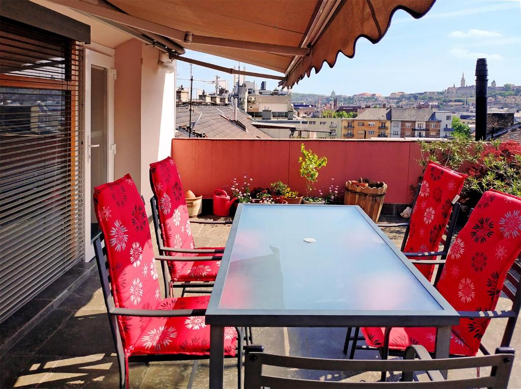 una mesa y sillas en un balcón con vistas en Margaret Apartment for 5 people with Panorama Terrace, en Budapest