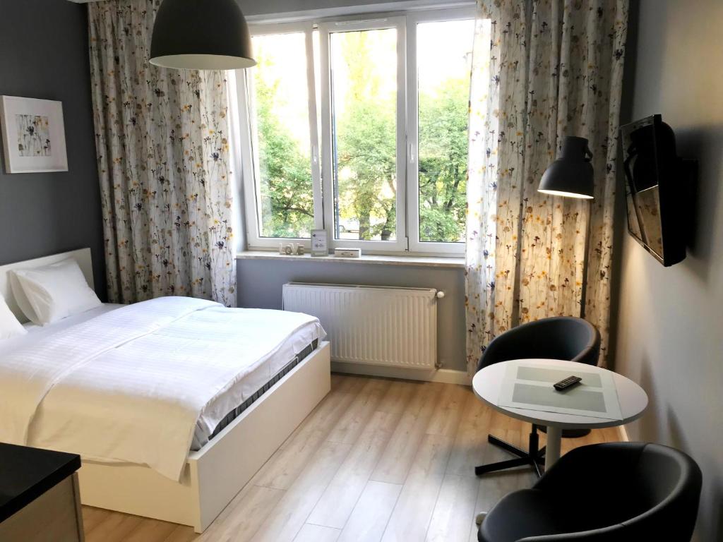 1 dormitorio con cama, mesa y ventana en Apartment II GrayFor2 Old Town Kraków, en Cracovia