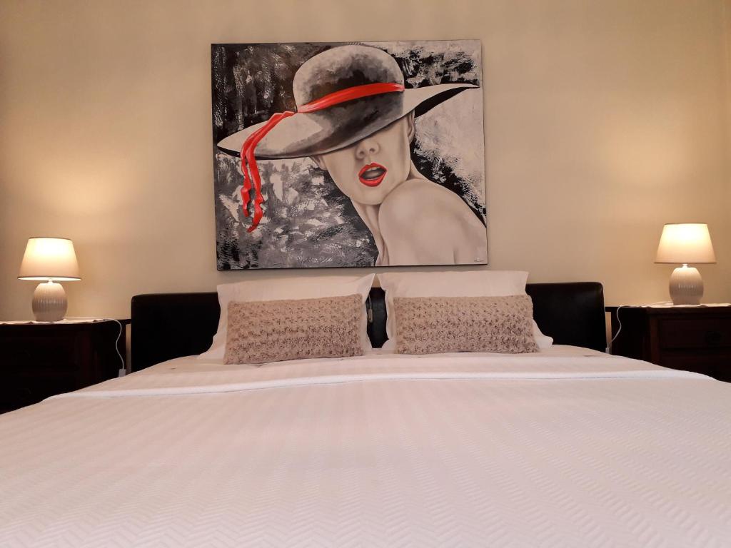 a bedroom with a bed with a painting on the wall at Apart. Av. António Feijó in Ponte de Lima