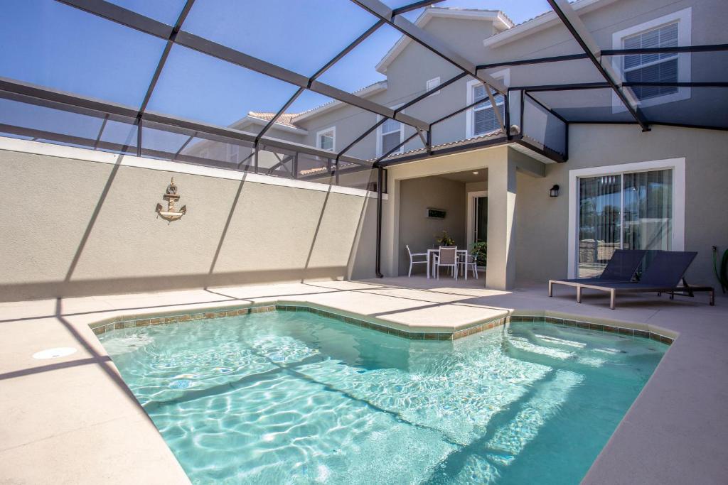 uma piscina com telhado de vidro numa casa em Luxurious 4Bd Home w/ Pool 4983 em Kissimmee