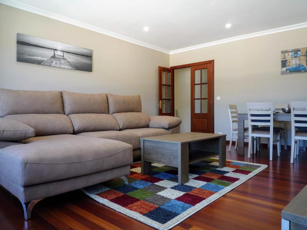 ein Wohnzimmer mit einem Sofa und einem Tisch in der Unterkunft Apartamento en Cee con vistas al mar in Cee