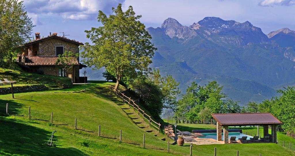 a house on a hill with mountains in the background at La Locanda del Moro in Pieve Fosciana