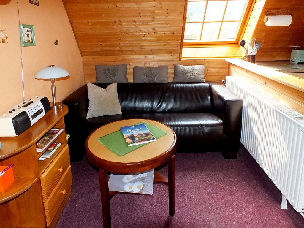 un soggiorno con divano in pelle e tavolo di Ferienwohnungen Schrot a Bad Schandau
