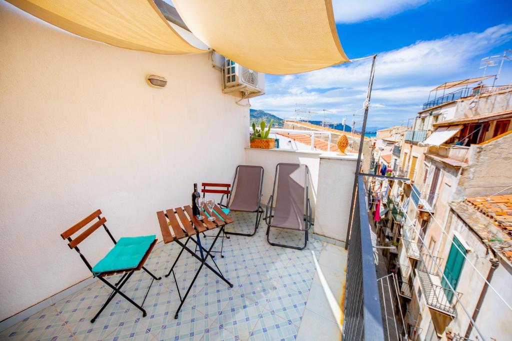 a balcony with chairs and a view of a city at Il terrazzino Holiday Home in Cefalù