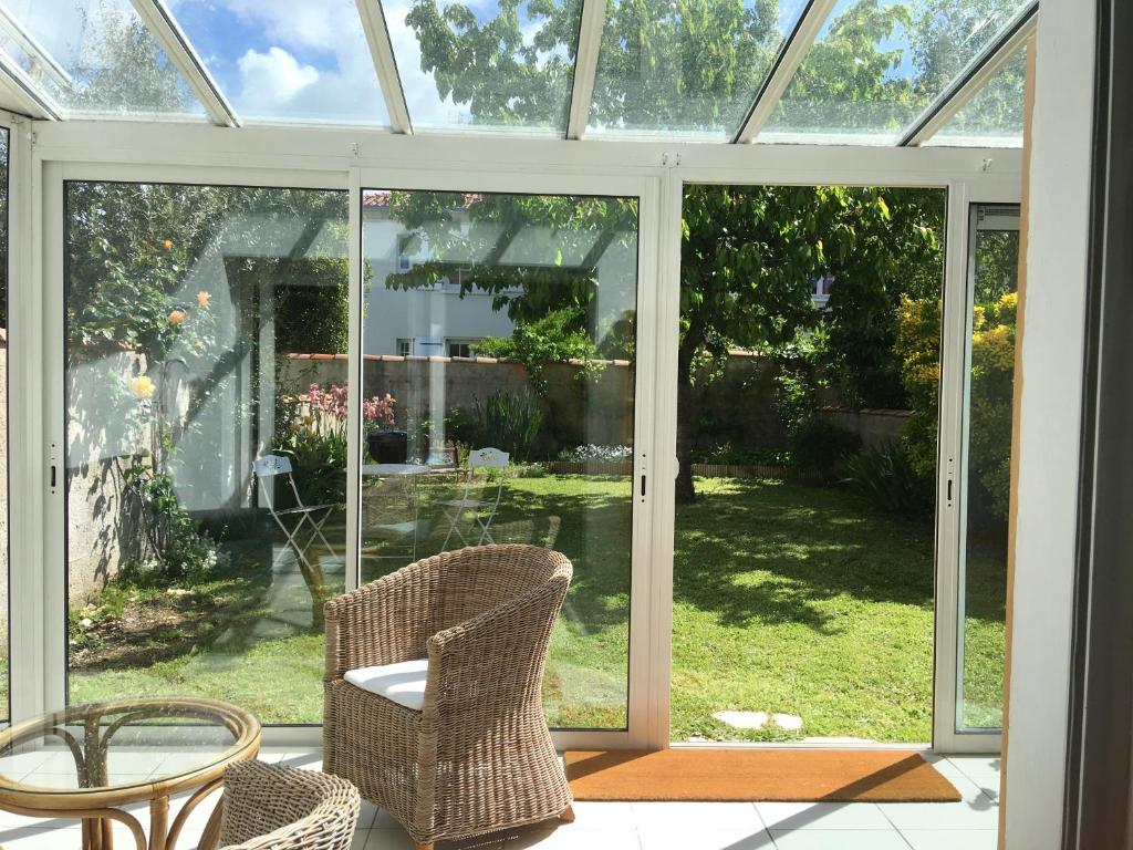 une véranda ouverte avec deux chaises et une table dans l'établissement La villa voyage, à La Rochelle