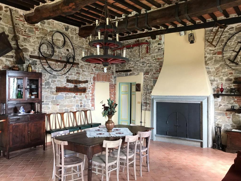 a dining room with a table and chairs and a brick wall at La Calona in Camaiore