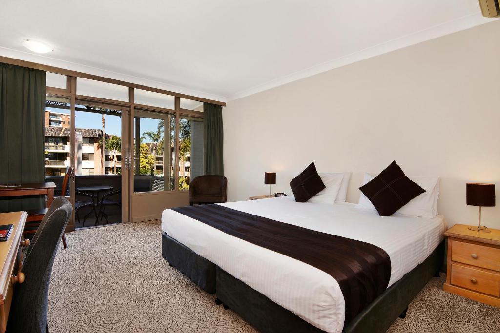 a hotel room with a large bed and a desk at Comfort Resort Waters Edge in Port Macquarie