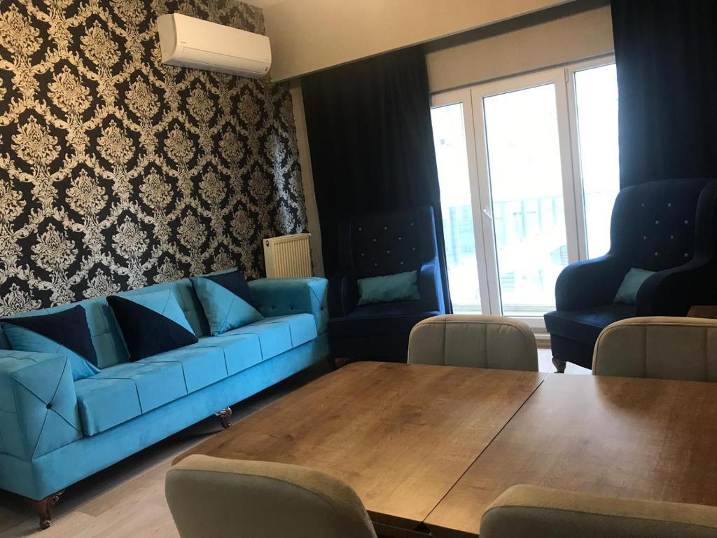 İkitelli的住宿－Başakşehir, Ayazma Mevkii Altınşehir Yanyol Masko Karşısı，客厅配有蓝色的沙发和木桌