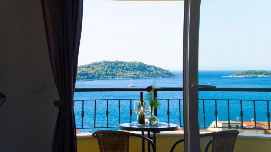 een tafel met uitzicht op de oceaan vanaf een balkon bij A lovely and cozy room with a breathtaking view in Vis
