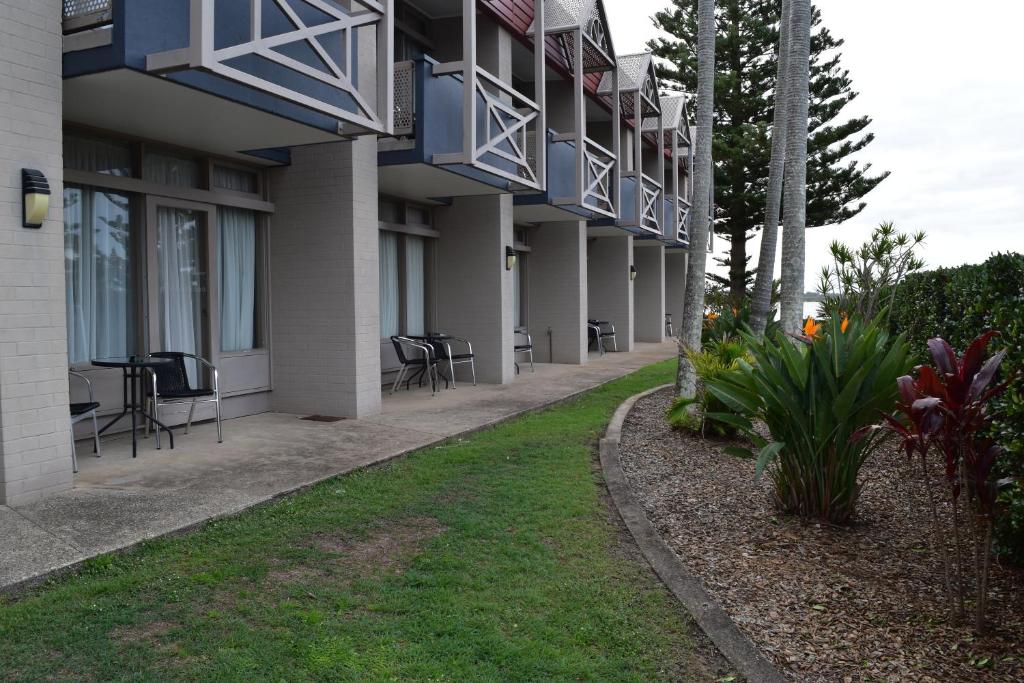 a side view of a building with chairs and tables at Comfort Resort Waters Edge in Port Macquarie