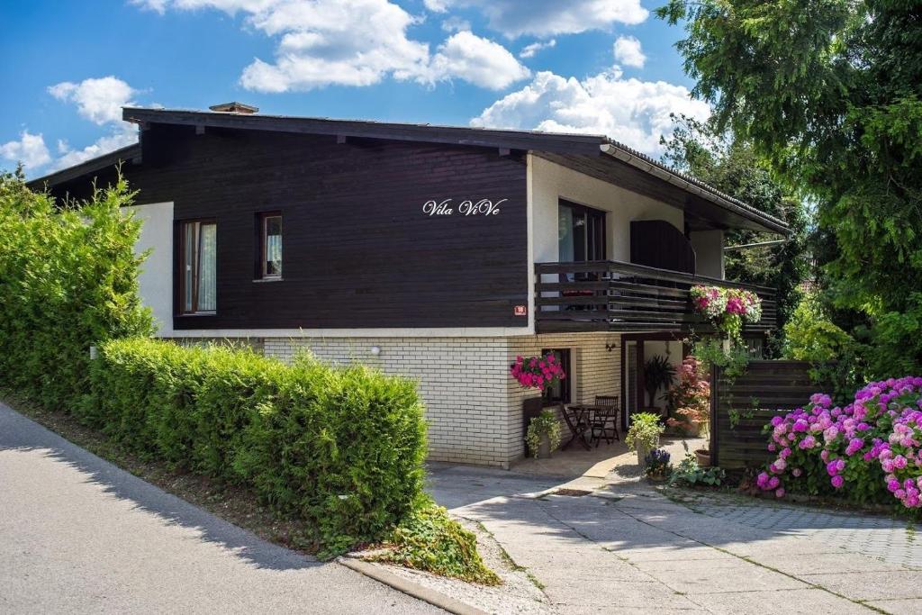 una casa negra con flores delante en Apartments and Rooms Villa Vive, en Bled