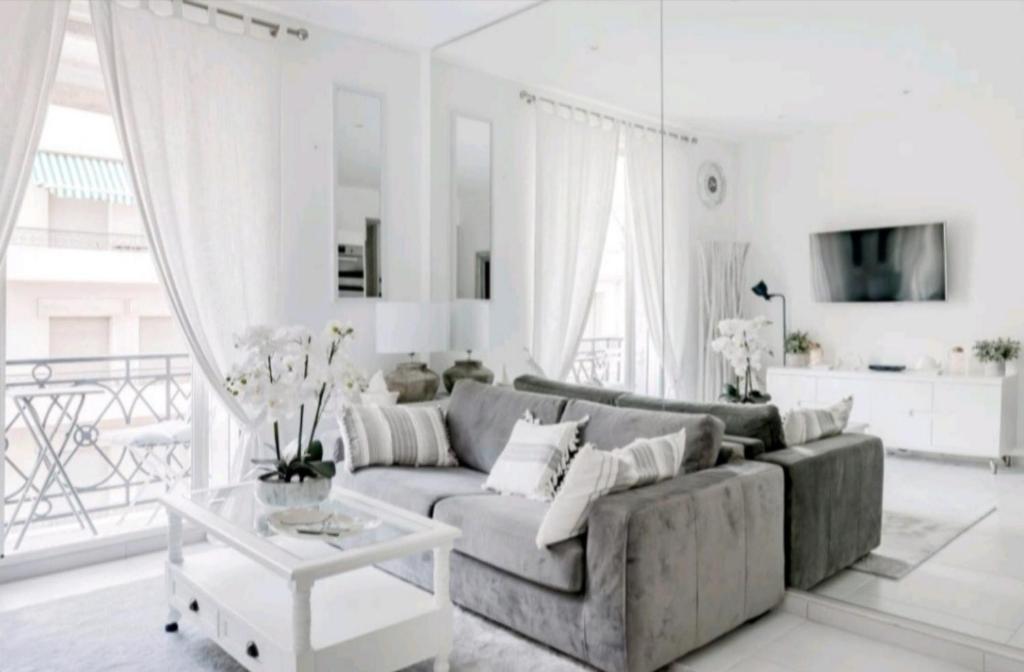 ein Wohnzimmer mit einem Sofa und einem Tisch in der Unterkunft PALAIS MIRAMAR CROISETTE APART 1 MIN CARLTON in Cannes