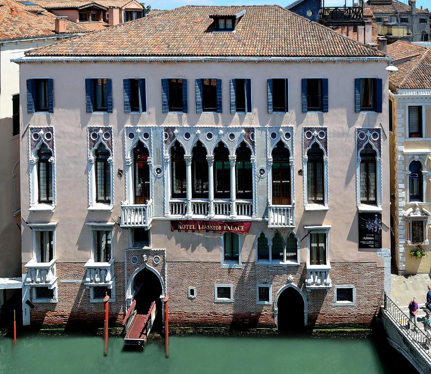 un grand bâtiment sur l'eau en face d'un canal dans l'établissement Hotel Liassidi Palace, à Venise