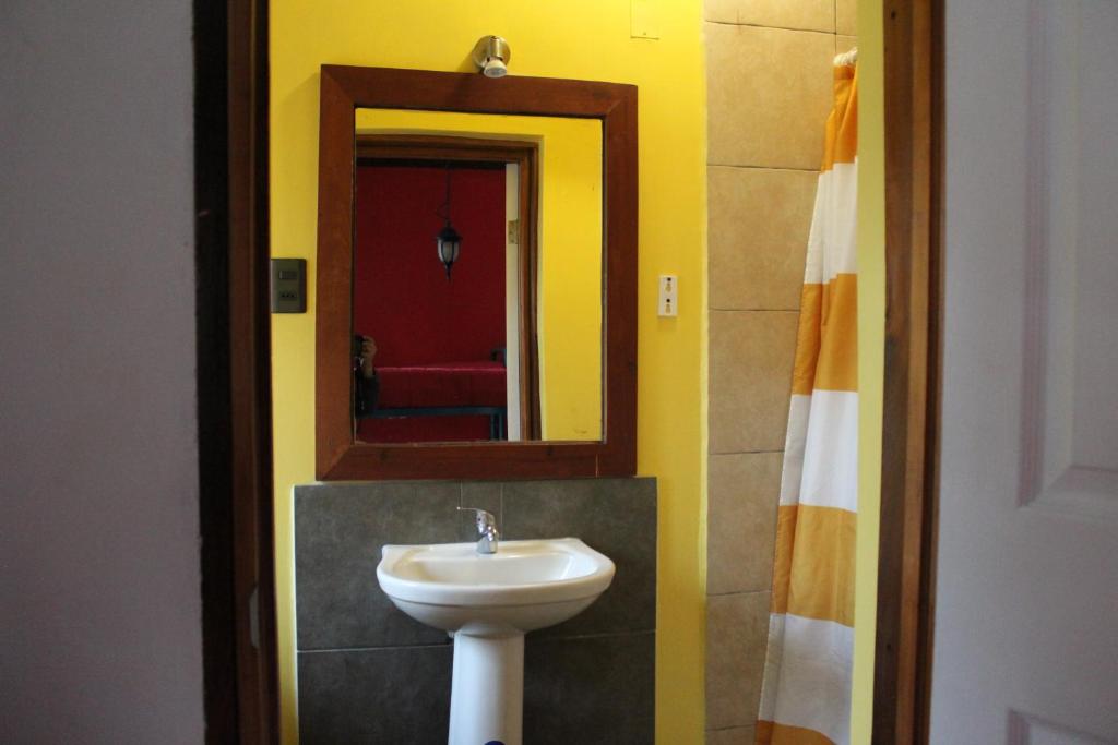 a bathroom with a sink and a mirror at Aji Hostel in Santiago