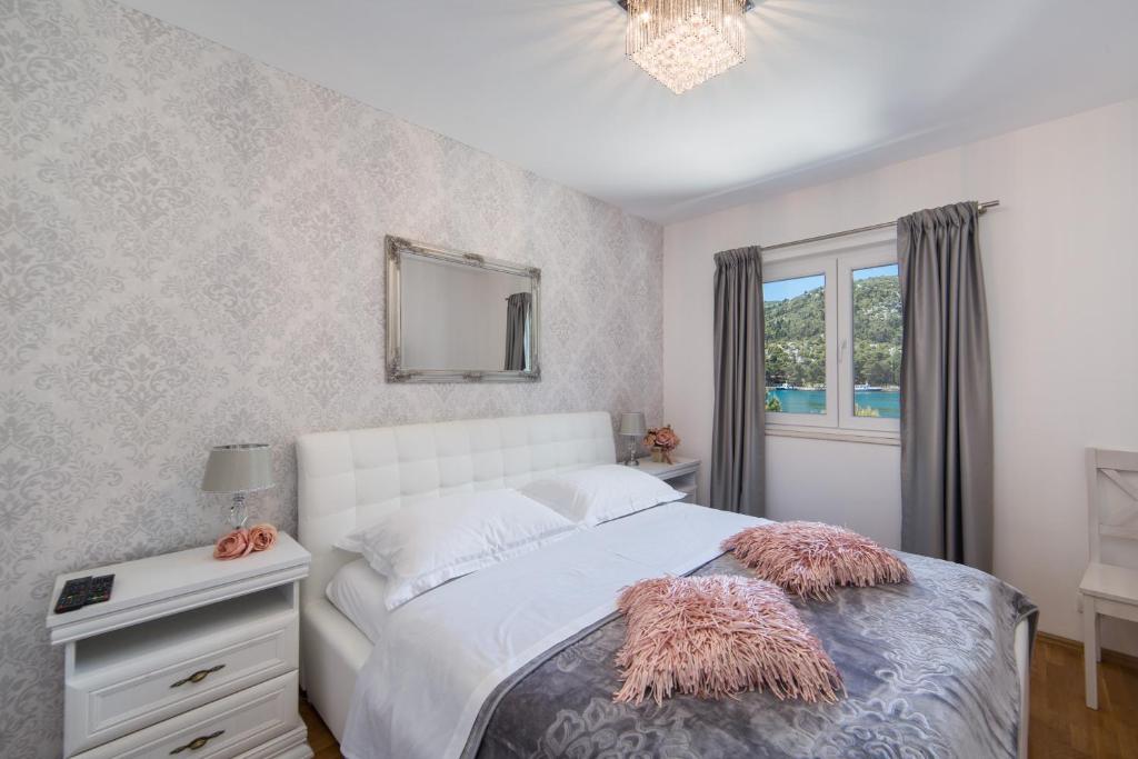 een slaapkamer met een wit bed en een raam bij Palma Luxury Apartment in Ploče