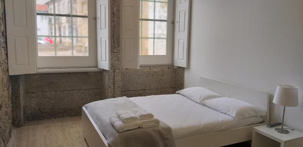 a bedroom with a bed with two towels on it at SÃO VICTOR Studios HISTORIC CENTER in Braga
