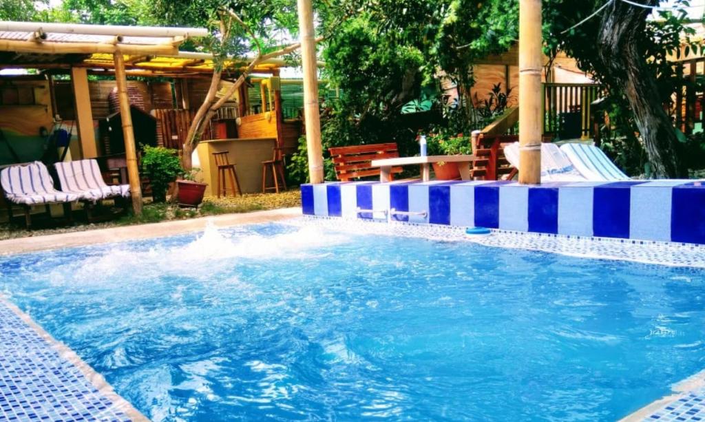 uma grande piscina com riscas azuis e brancas em Rincón d'Olón Boutique Hotel em Olón