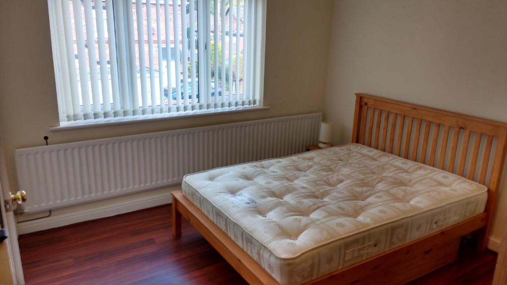 a bed in a room with a large window at East Park House in Wolverhampton