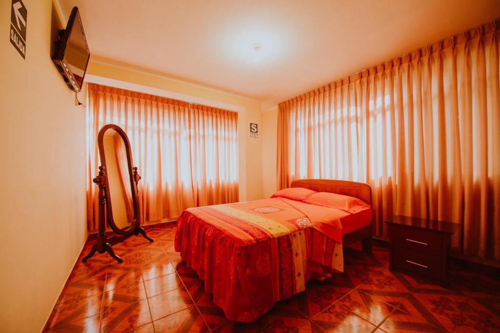 1 dormitorio con cama y ventana grande en Hotel Las Viñas, en Huánuco