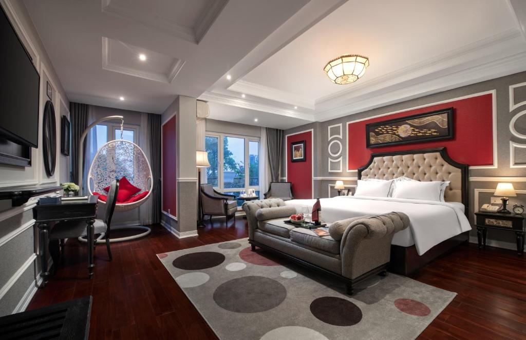 a bedroom with a bed and a couch and a desk at Acoustic Hotel & Spa in Hanoi