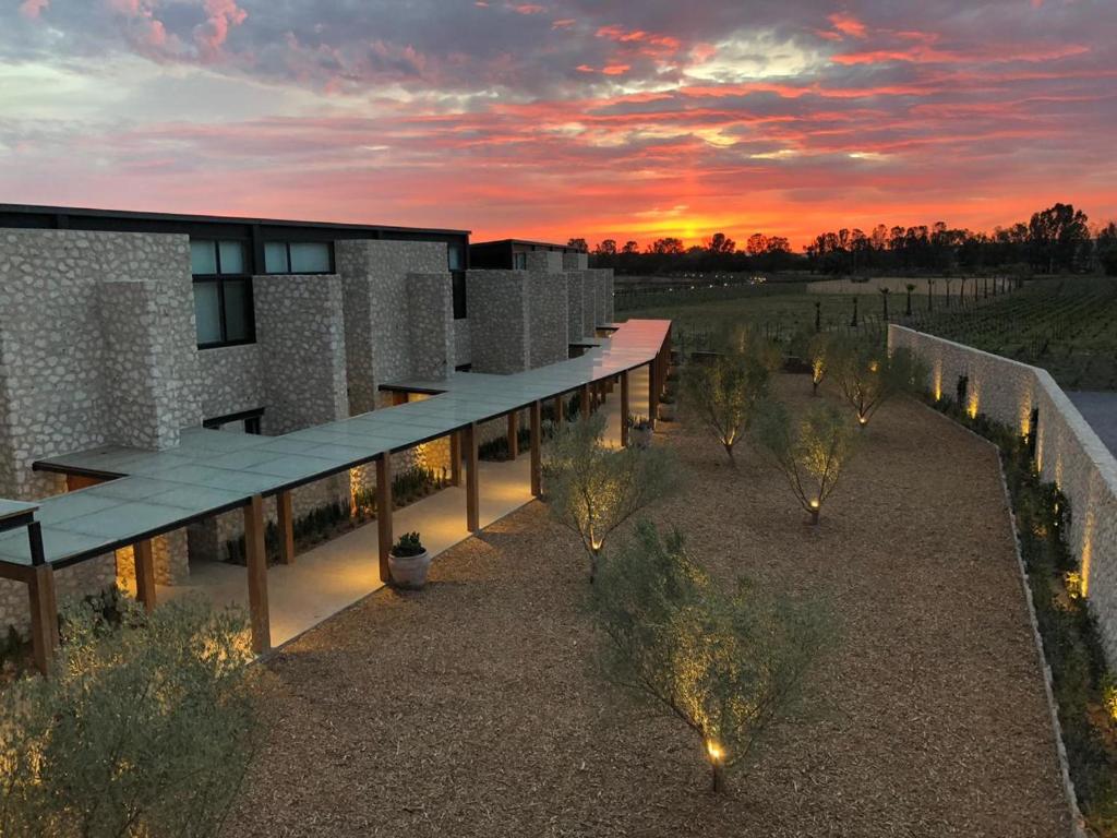 une vue de tête d'un bâtiment avec un coucher de soleil en arrière-plan dans l'établissement Viñedos San Francisco, à San Miguel de Allende