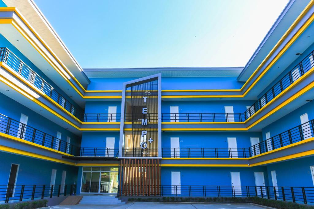 an exterior view of a blue building with balconies at Tempo Plus Apartment in Mae Sot