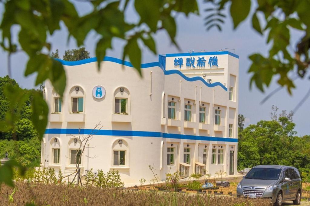 um edifício com um carro estacionado em frente em Cicada said Greece Homestay em Jinning
